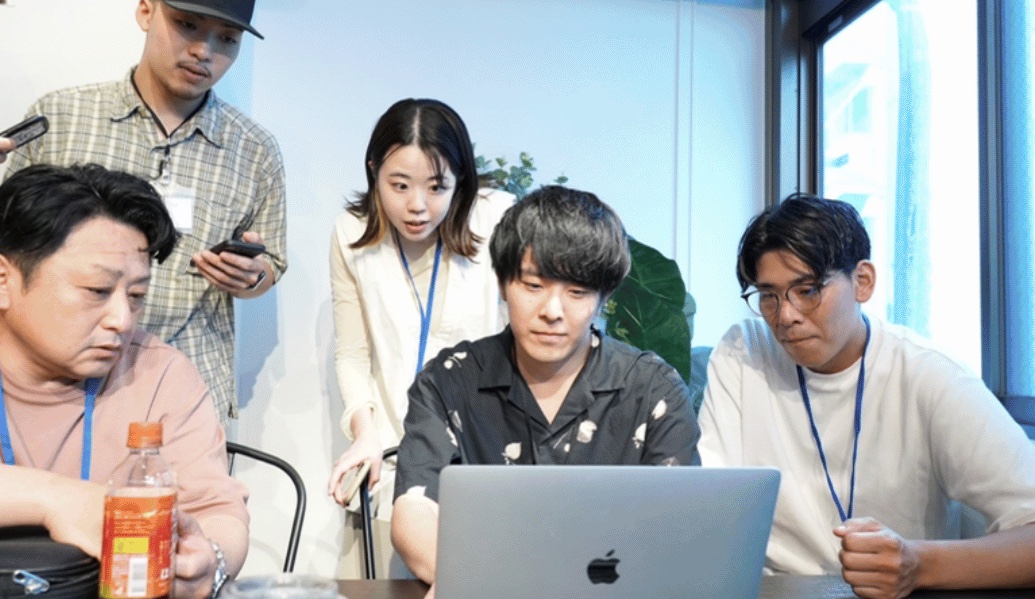 講師と受講生がパソコンを囲んで作業している様子
